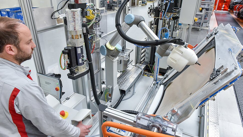 Ein MRK-Roboter kommt im Audi-Stammwerk Ingolstadt in der Endmontage zum Einsatz. Er arbeitet ohne Schutzzaun gemeinsam mit einem Menschen. Foto: Audi