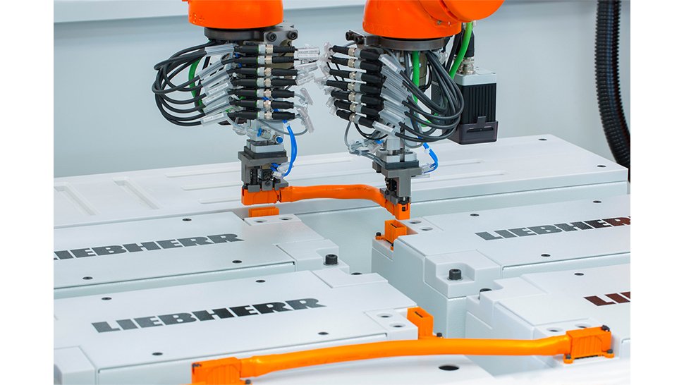 Zwei kooperierende Roboter greifen jeweils ein Ende des Kabels und führen den Steckprozess synchron durch.