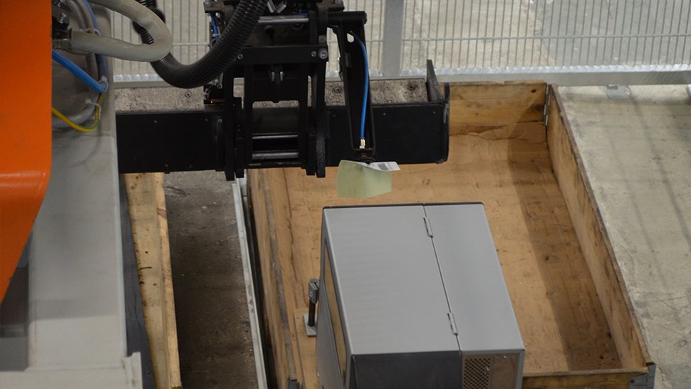 Mit einem Vakuumgreifer holt der Roboter Etiketten von einem Drucker ab und platziert diese in den jeweiligen Behältern.