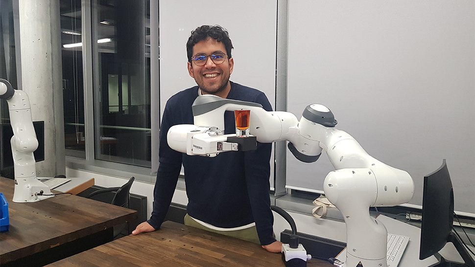 Dr. Luis Figueredo aus dem Robotikinstitut MIRMI der TU München (TUM) bringt einem Roboter bei, ein mit Wasser gefülltes Glas zu transportieren. Foto: Wolfgang Maria Weber/TUM