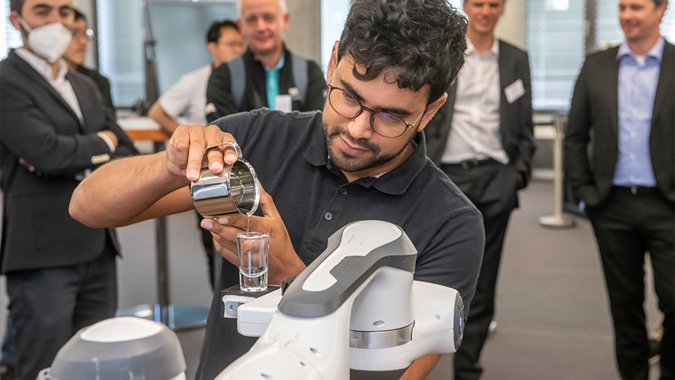 Dr. Luis Figueredo aus dem Robotikinstitut MIRMI der TU München (TUM) bringt einem Roboter bei, ein mit Wasser gefülltes Glas zu transportieren. Foto: Wolfgang Maria Weber/TUM
